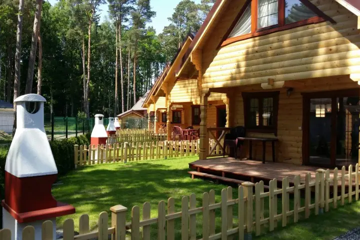 Drewniane domki nad morzem z psem czekają na gości. Piękny ogród i grill zachęcają do wypoczynku.