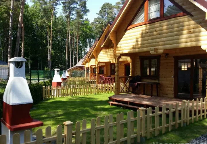 Drewniane domki nad morzem z psem czekają na gości. Piękny ogród i grill zachęcają do wypoczynku.